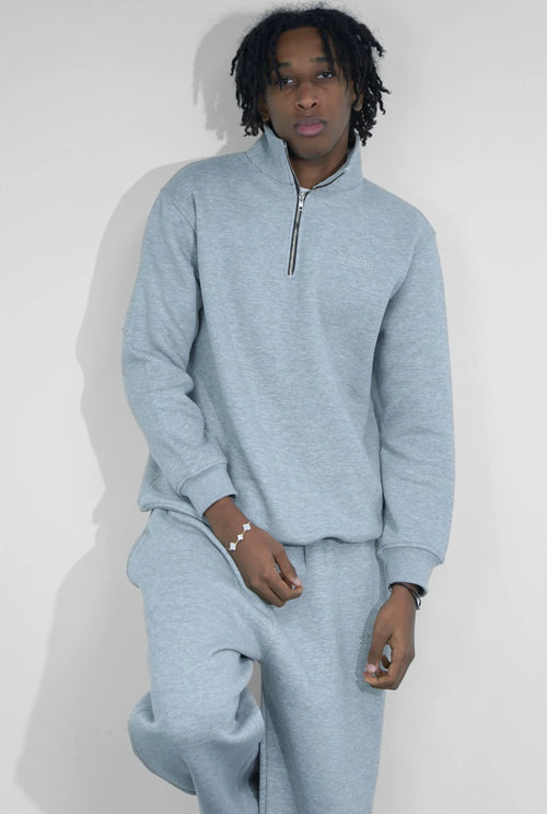 Man wearing light grey quarter-zip sweatshirt and sweatpants set, casual fashion